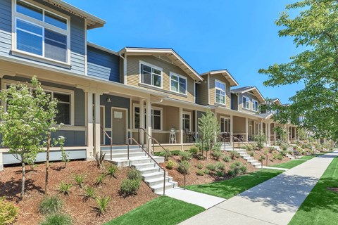 a row of houses with stairs and a sidewalk